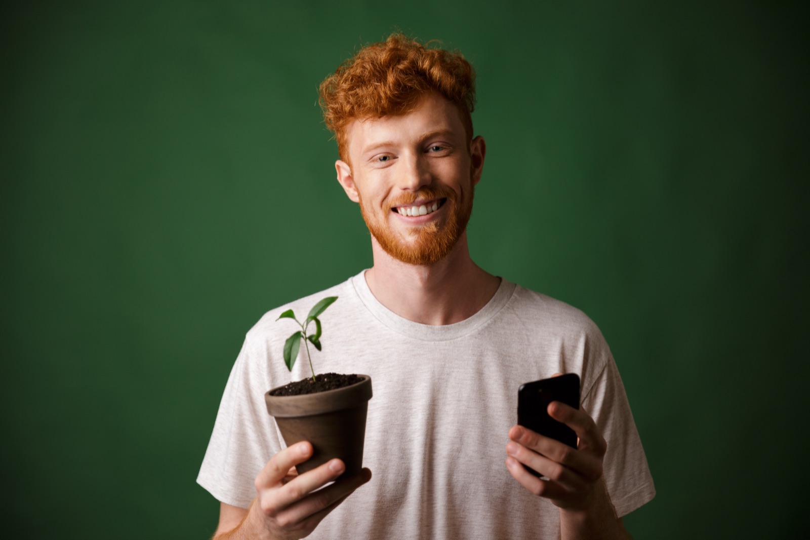 Pessoa sorrindo e segurando uma planta